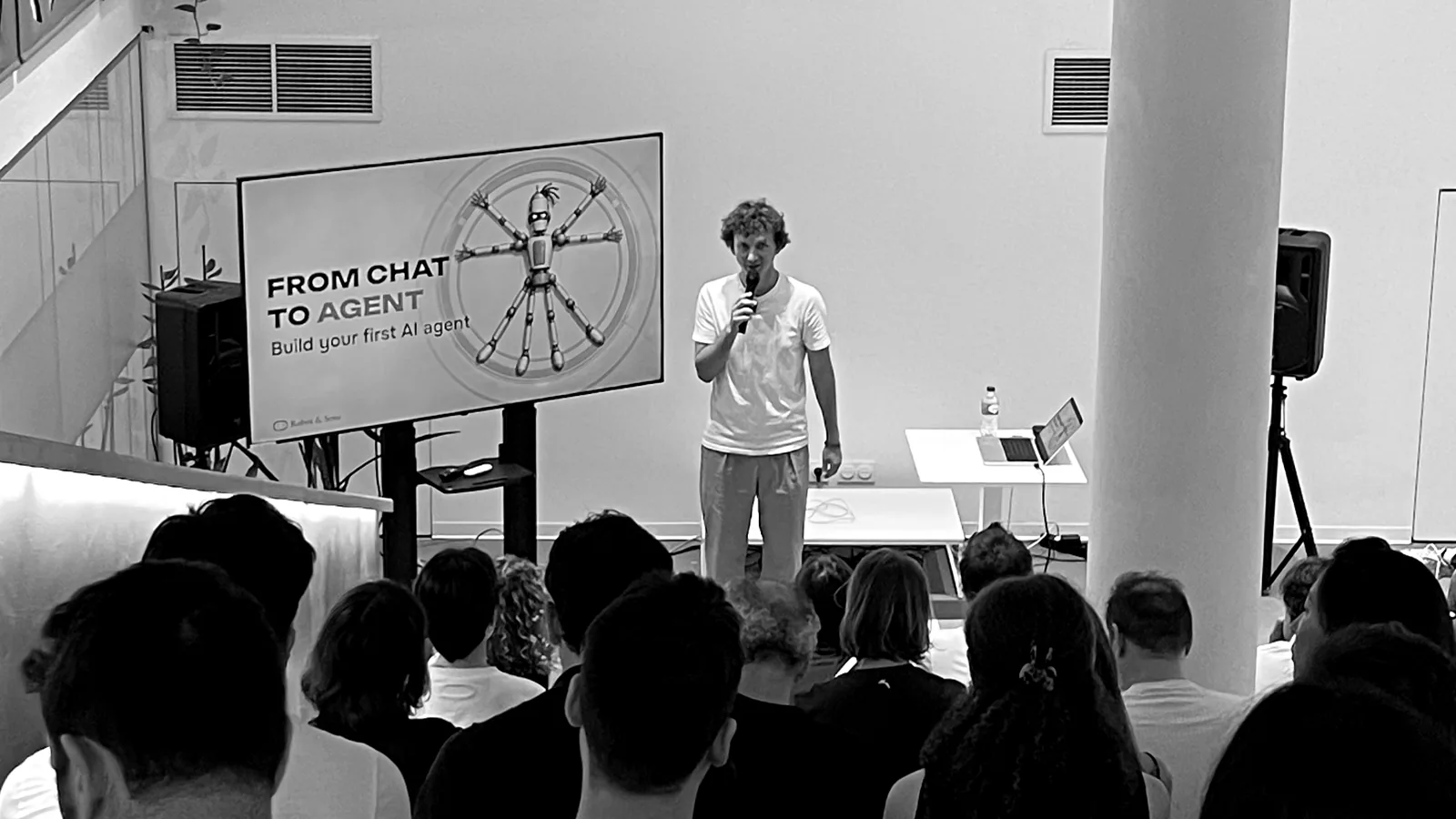 The room at the free Lisbon AI Week evening, Egor presenting at the screen